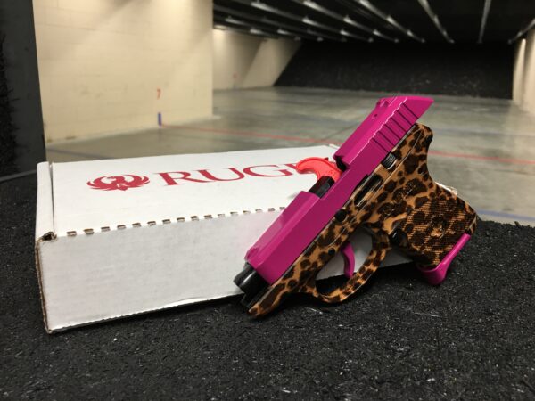 This is a front left side view of the custom ruger lcp .380 pistol customized in magenta solid color on the firearm slide, trigger, and magazine, while boasting the vivid Cheetah print on the firearms frame