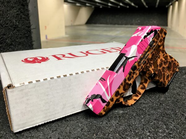 Ruger LCP .380 ACP with customized Cheetah print frame and Pink Camo pattern slide to complete its pink gun finish. Featured in the indoor gun range Captured from the front left side of the firearm