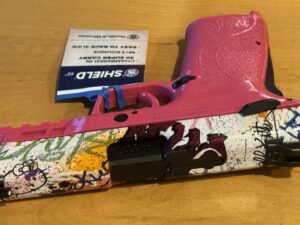 Pink Smith & Wesson M&P Super Carry chambered in 30 Super Carry with Hello Kitty-inspired graffiti custom slide